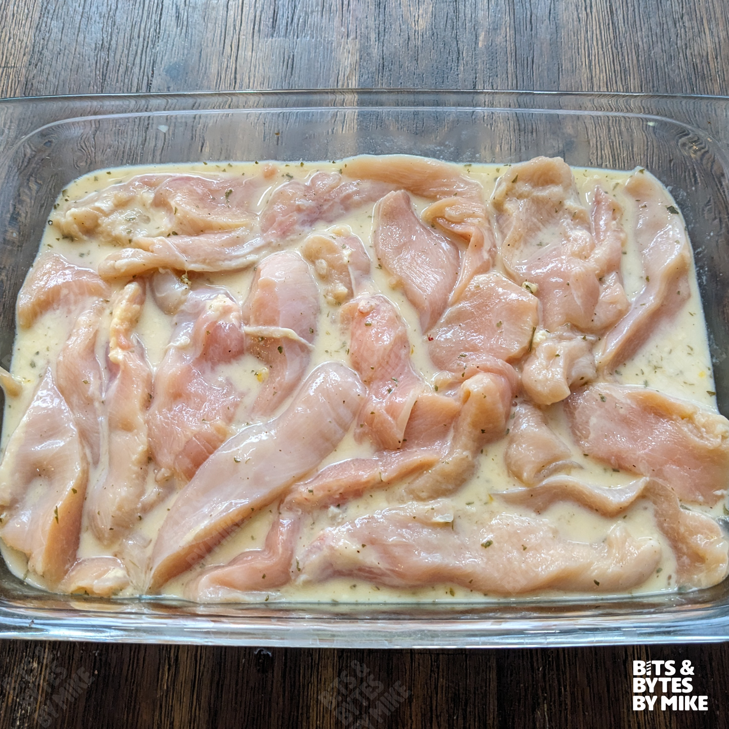 Chicken tenders marinating in ranch, milk, and egg mixture.